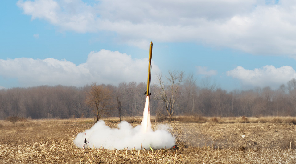 The 2024 Notre Dame Rocketry Team rocket launches from a field