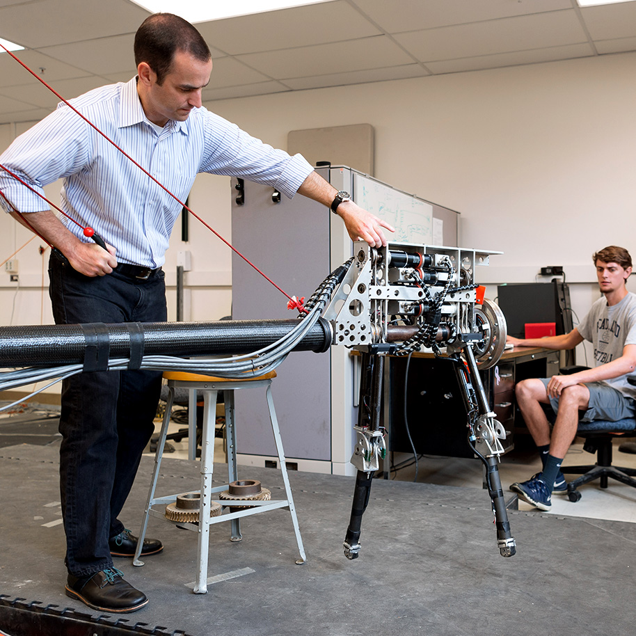 Professor Jim Schmiedeler with "Ernie," a walking robot.